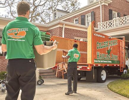 Two hunks hauling junk to orange truck