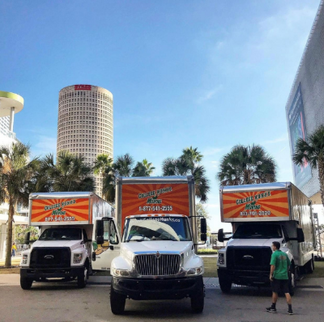 College HUNKS moving trucks with Downtown Tampa in the background.